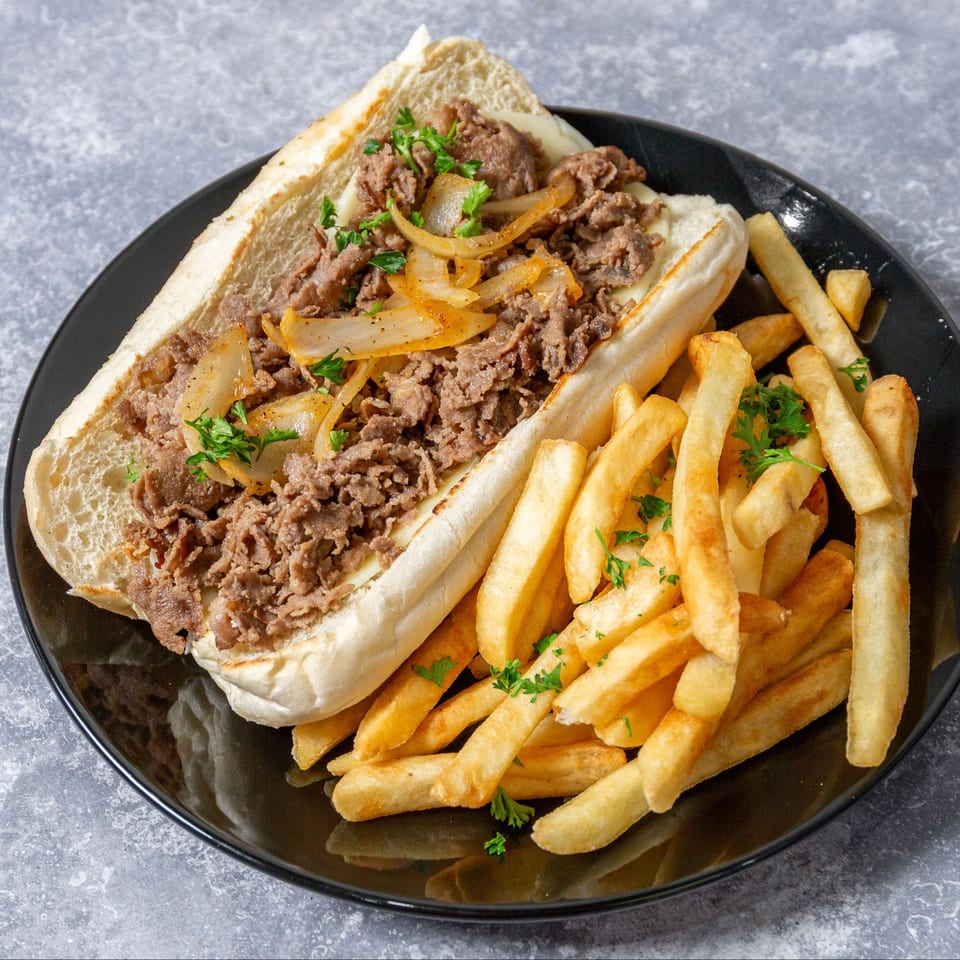 Taza Grill's Mediterranean steak and cheese sub with grilled onions and parsley, served with french fries.