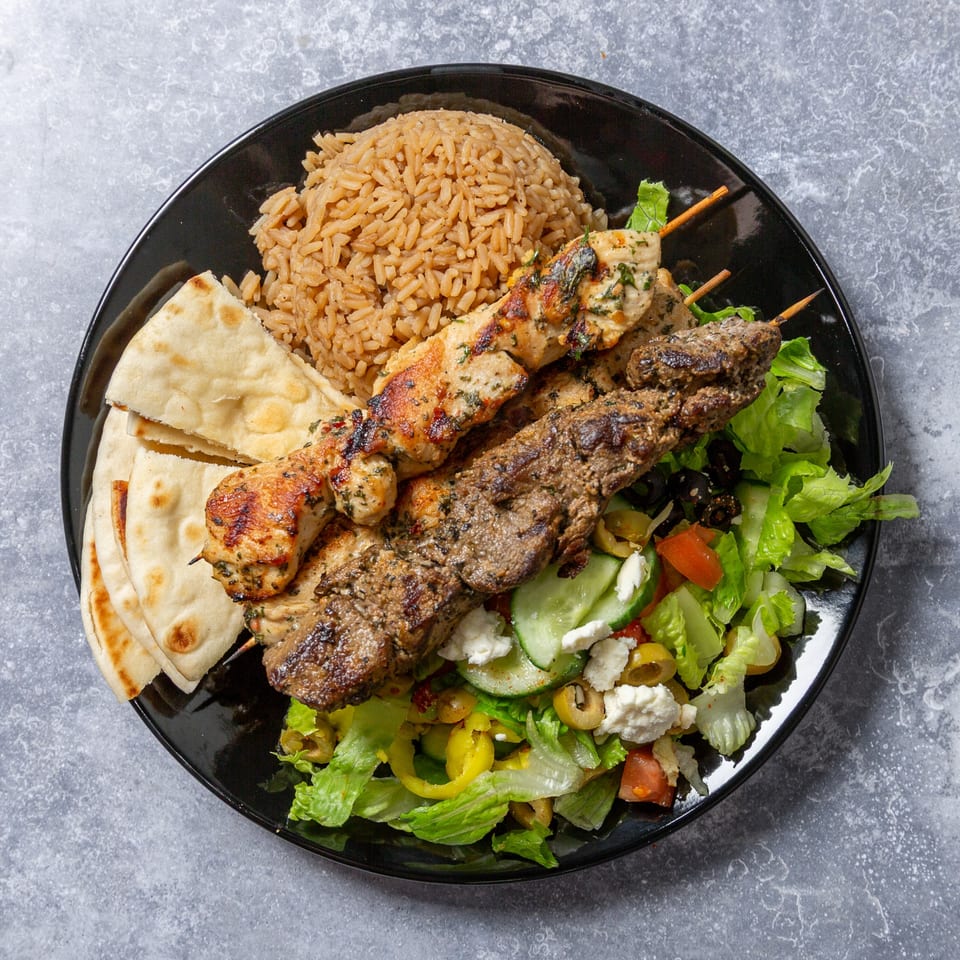 Taza Grill's Mediterranean platter with chicken and beef kebabs, rice, pita bread, and Greek salad.