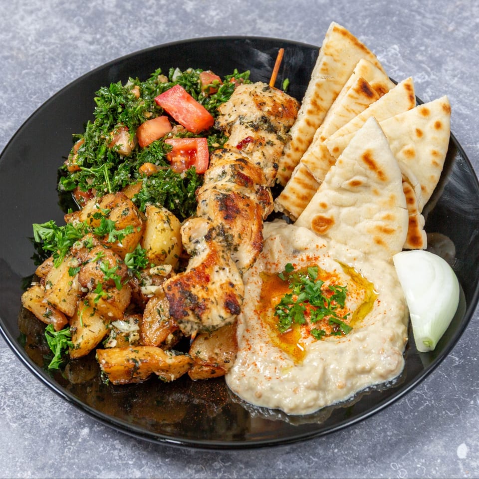 Taza Grill's Mediterranean platter with chicken shish tawook, hummus, pita, tabbouleh, and potatoes.